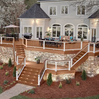 La terrasse composite Trex Transcend et la rampe brun moyen Tree House et brun foncé Vintage Lantern créent une oasis extérieure qui peut accueillir de nombreux invités