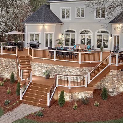 Las barandillas y terrazas Trex Transcend de color marrón Tree House y marrón oscuro Vintage Lantern crean un oasis exterior con gran cantidad de asientos