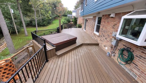Trex deck and bench surrounding a inserted hot tub