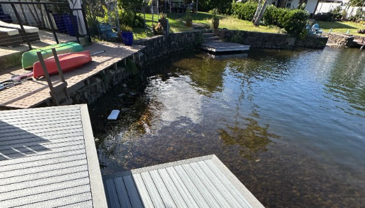 The Kailua deck features Foggy Wharf decking with a Pebble Grey picture frame border and custom steps, designed for a sleek and modern look.