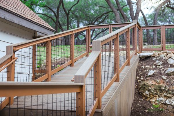 Trex deck ramp with wood-and-wire railing on a sloped Hill Country lot