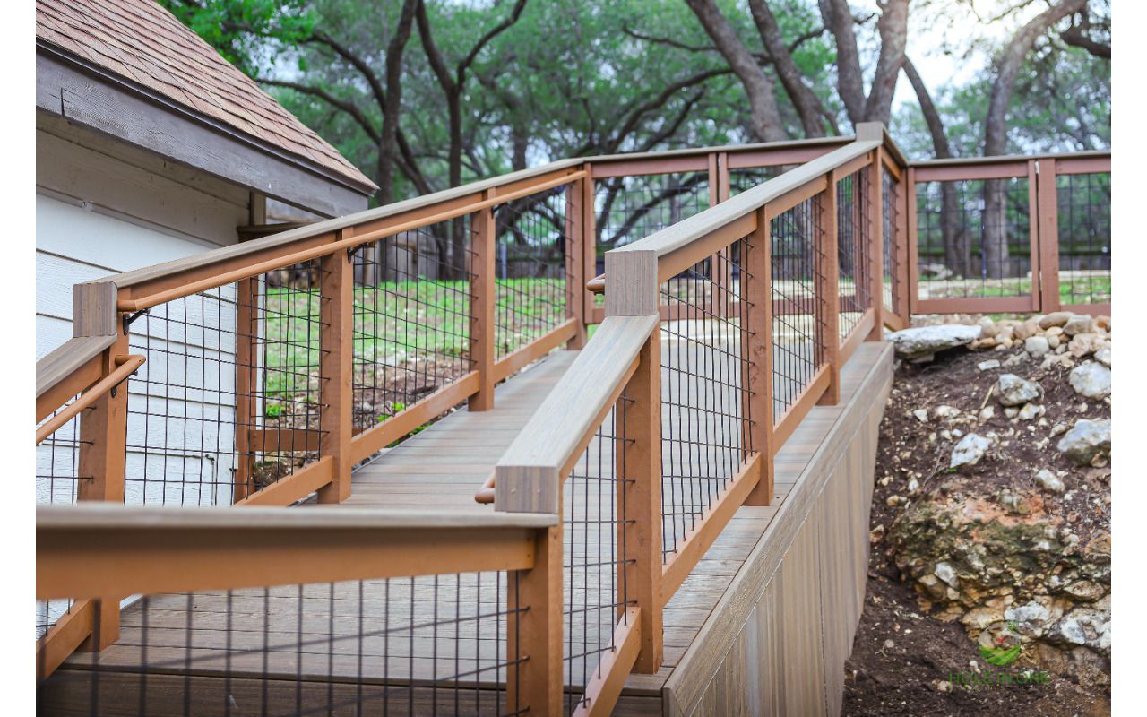 Trex deck ramp with wood-and-wire railing on a sloped Hill Country lot