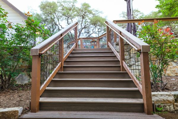 Trex composite staircase with wire-panel railing climbing a hillside