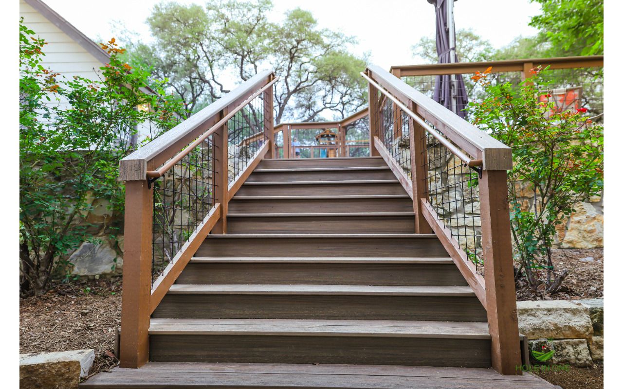Trex composite staircase with wire-panel railing climbing a hillside