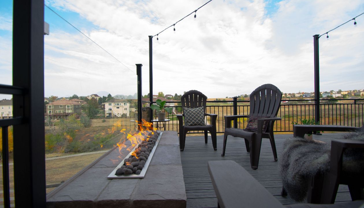 Castle Rock, CO Trex Transcend deck in Island Mist with iron rail, custom fire pit with fire glass behind