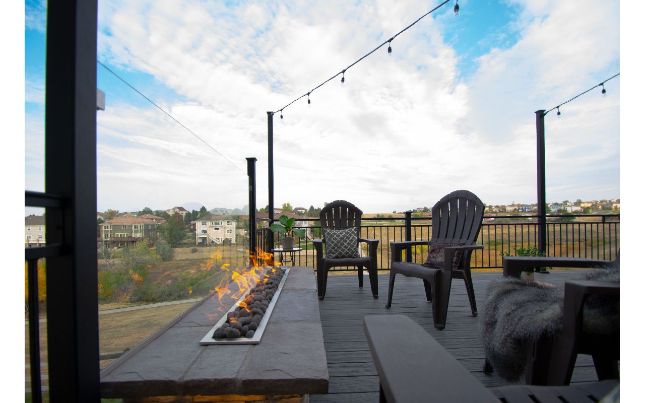 Castle Rock, CO Trex Transcend deck in Island Mist with iron rail, custom fire pit with fire glass behind