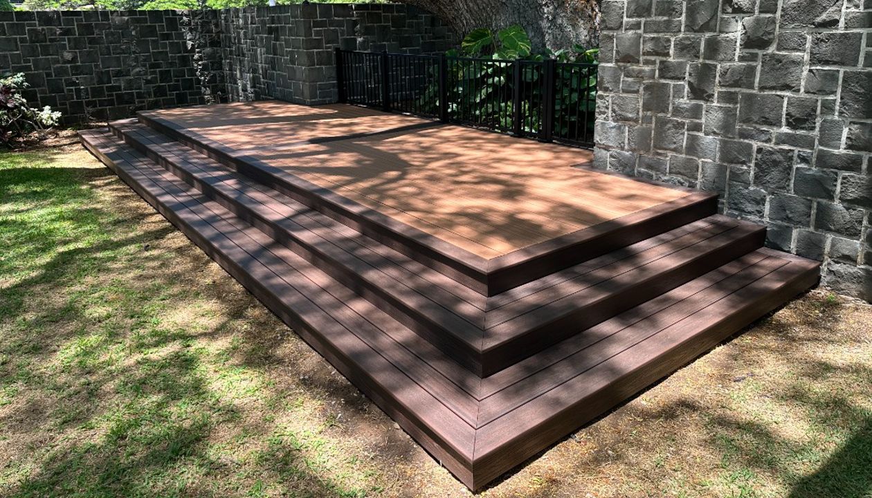 The deck is made with Trex Transcend® Tiki Torch decking, Lava Rock trim, and black Trex Signature® railing, designed for a seamless and elegant finish.