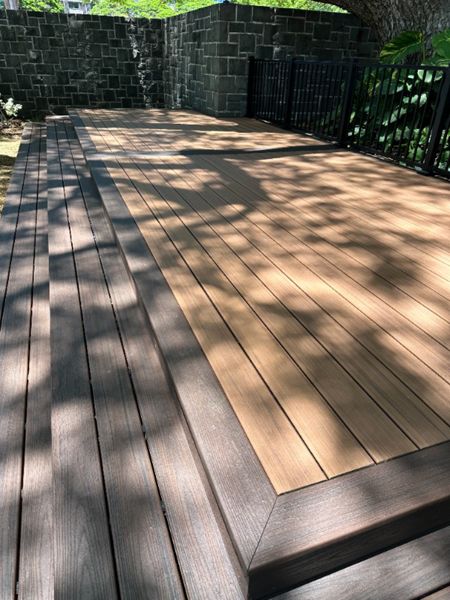 The deck is made with Trex Transcend® Tiki Torch decking, Lava Rock trim, and black Trex Signature® railing, designed for a seamless and elegant finish.