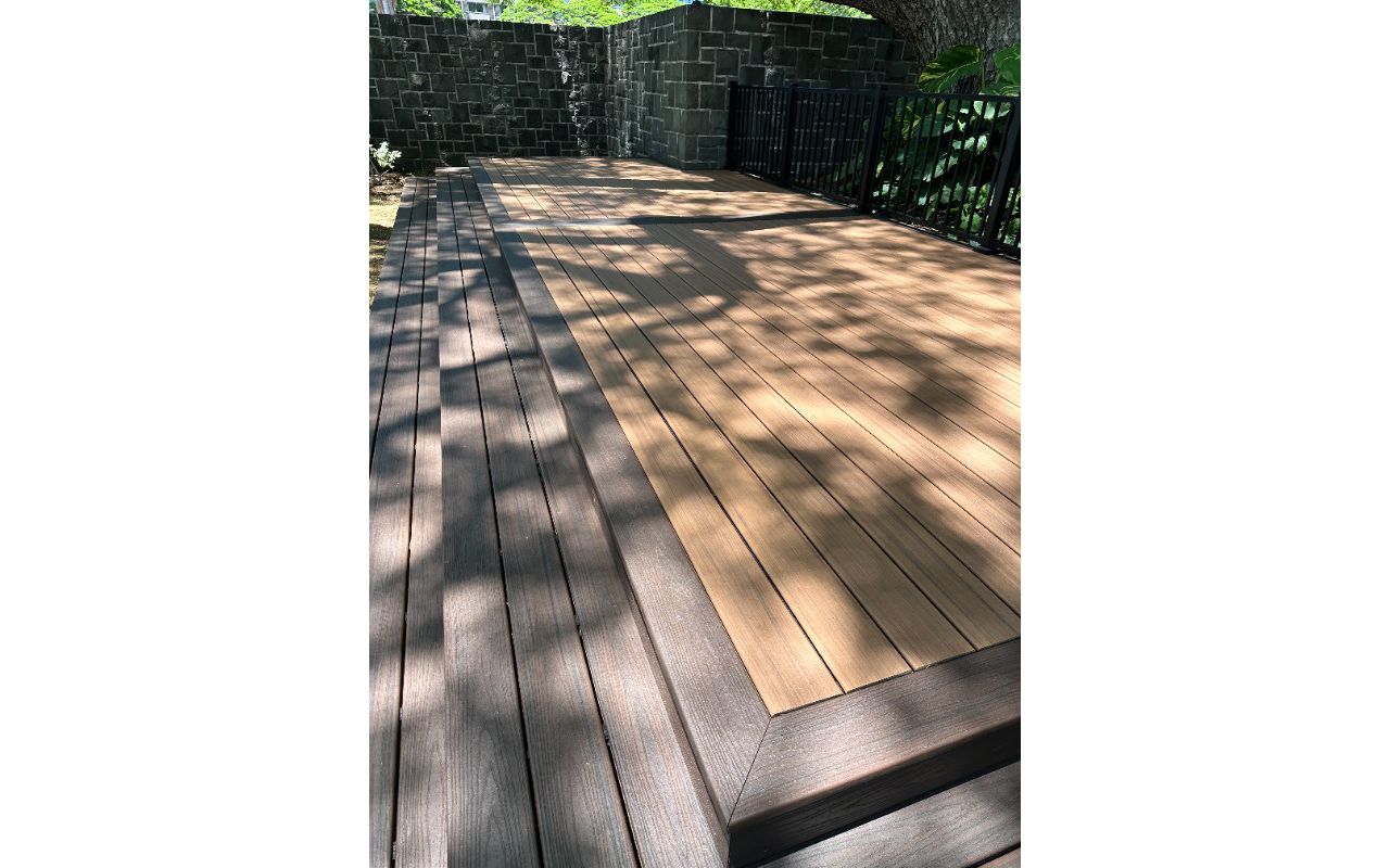 The deck is made with Trex Transcend® Tiki Torch decking, Lava Rock trim, and black Trex Signature® railing, designed for a seamless and elegant finish.