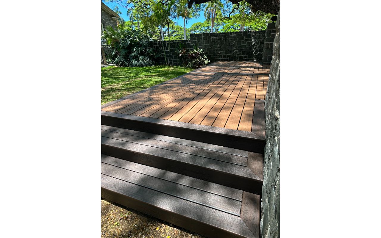 The deck is made with Trex Transcend® Tiki Torch decking, Lava Rock trim, and black Trex Signature® railing, designed for a seamless and elegant finish.