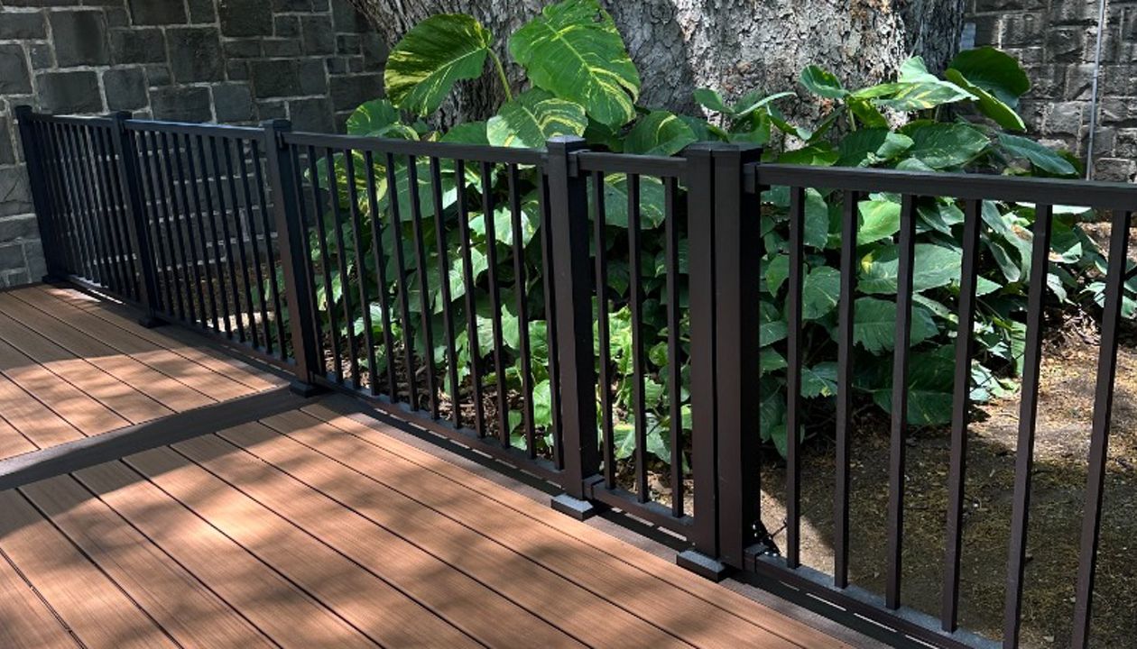 The deck is made with Trex Transcend® Tiki Torch decking, Lava Rock trim, and black Trex Signature® railing, designed for a seamless and elegant finish.