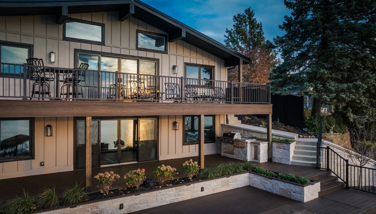 Elevated composite deck with aluminum railing and a custom outdoor kitchen designed for entertaining and sunset views.