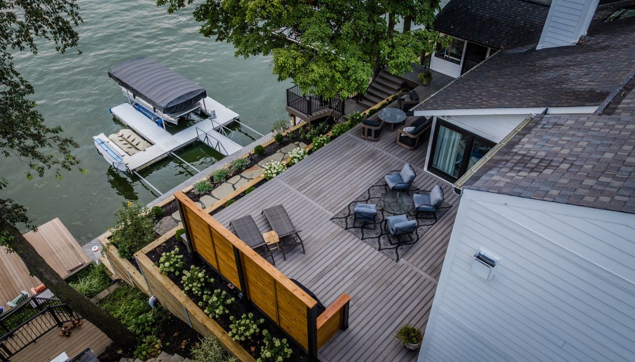 Waterfront composite deck connected to terraced landscaping and a private boat dock for seamless lakefront living.