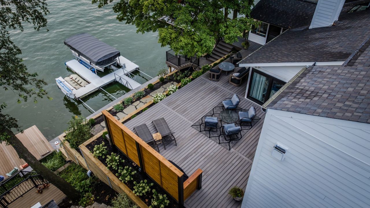 Waterfront composite deck connected to terraced landscaping and a private boat dock for seamless lakefront living.