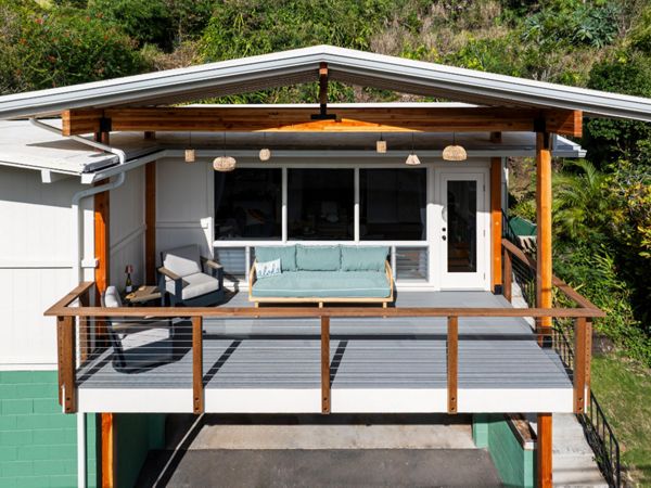 The new permitted deck in Honolulu features Pebble Grey decking and a custom cable Ipe railing for a stylish and durable design.