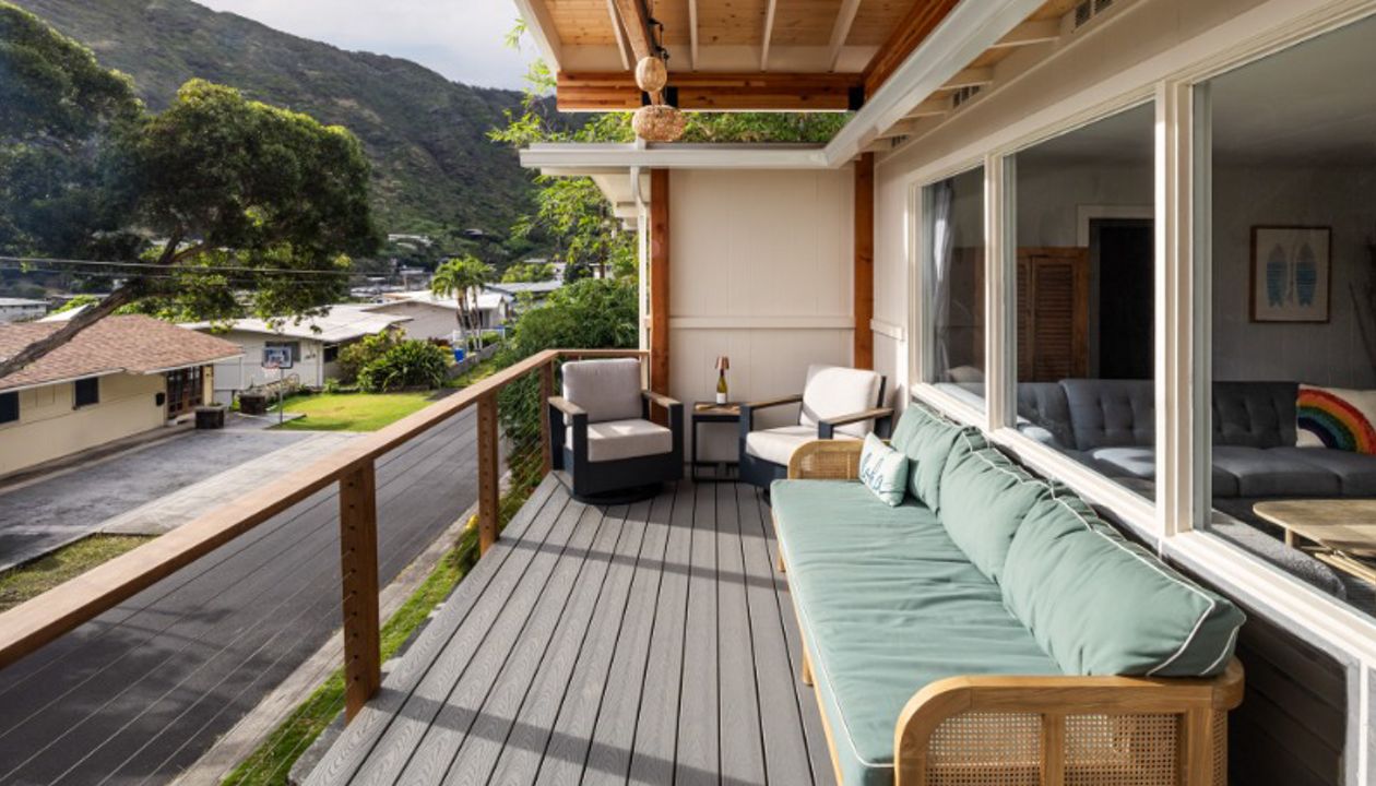 The new permitted deck in Honolulu features Pebble Grey decking and a custom cable Ipe railing for a stylish and durable design.