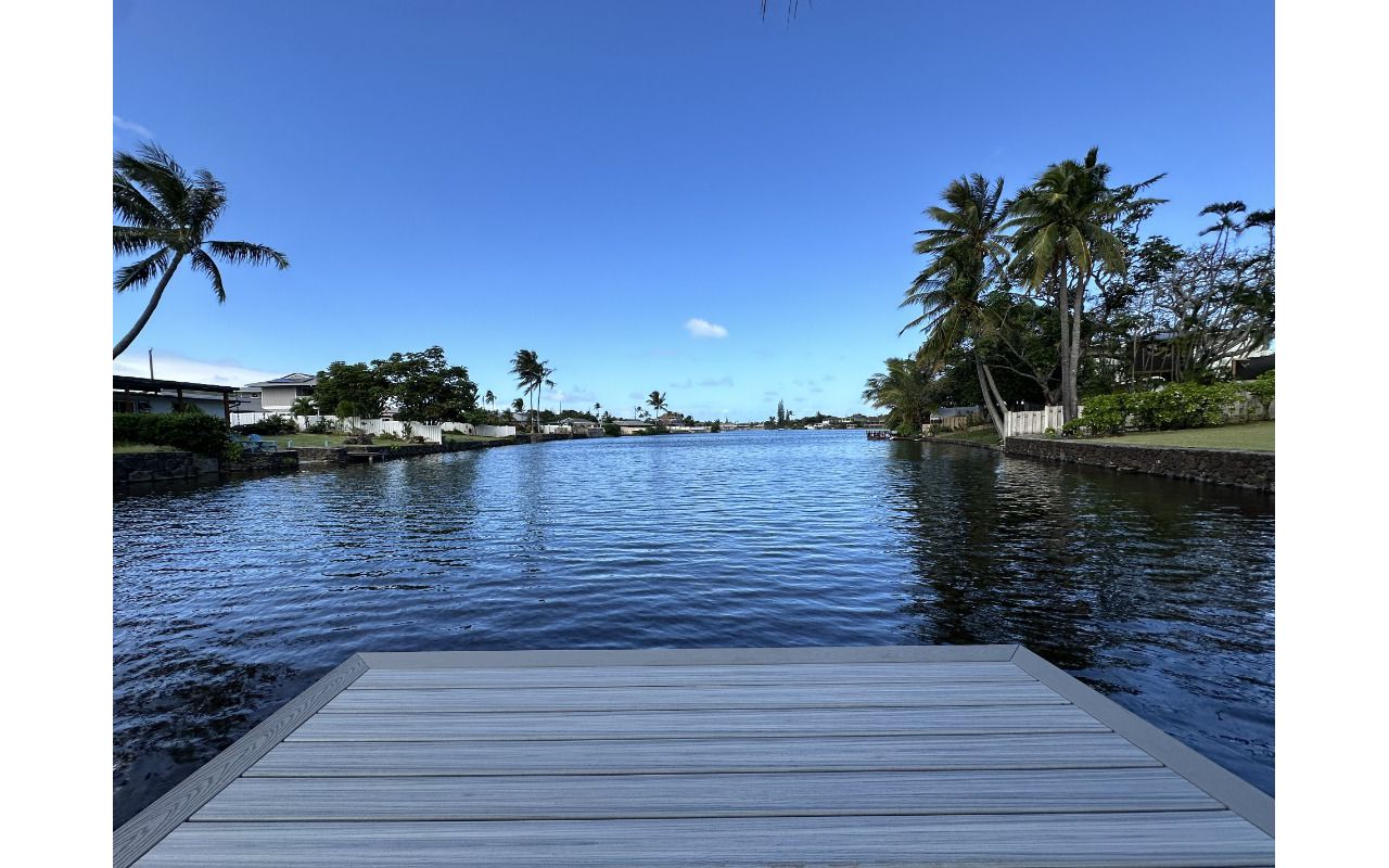 The Kailua deck features Foggy Wharf decking with a Pebble Grey picture frame border and custom steps, designed for a sleek and modern look.