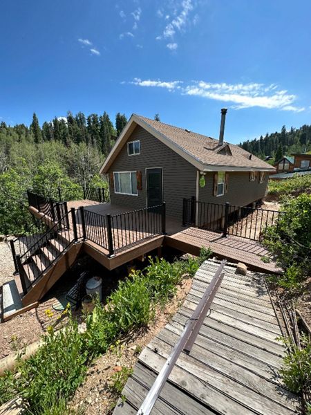 Nestled in the woods, this cabin deck features Trex Select® Saddle decking and sleek Trex® Signature steel railing — blending rustic charm with modern strength.