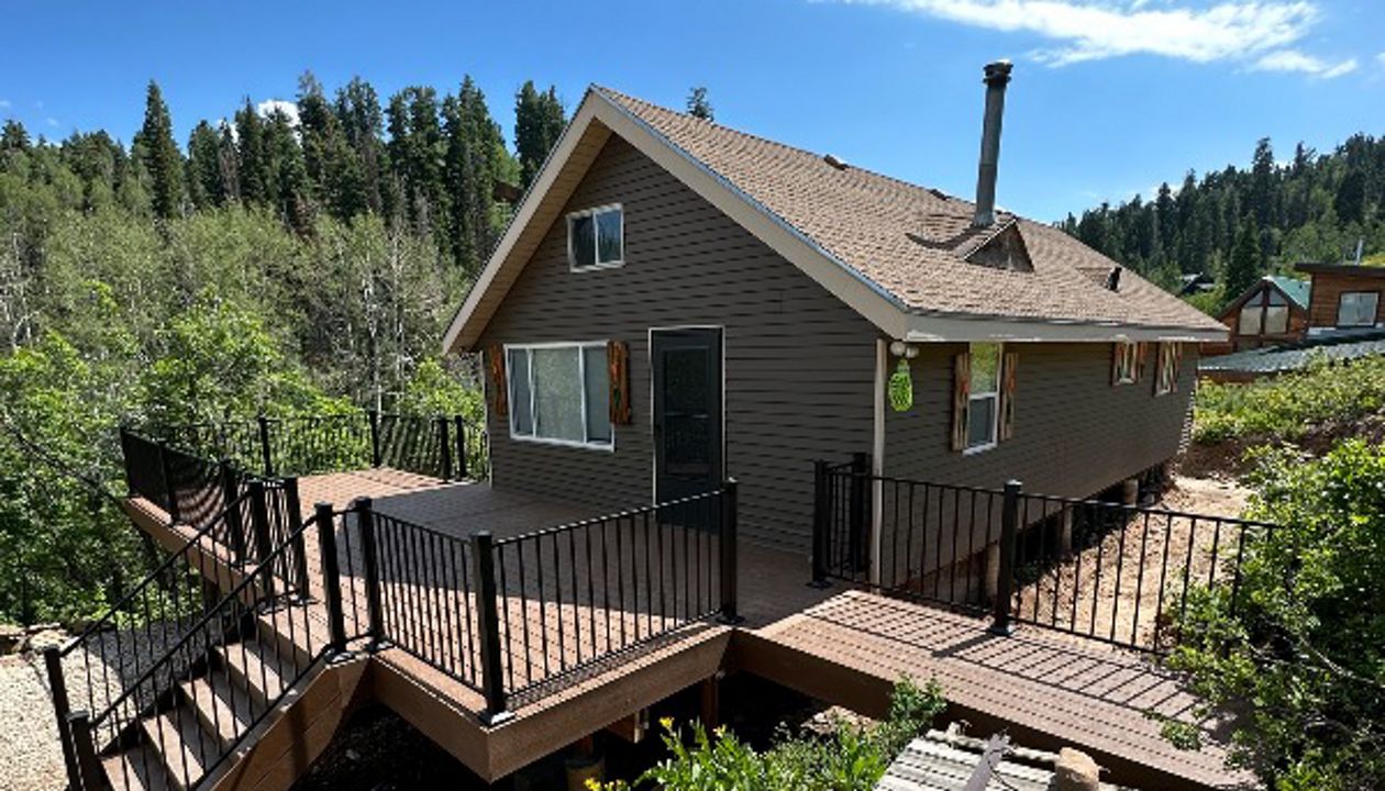 Nestled in the woods, this cabin deck features Trex Select® Saddle decking and sleek Trex® Signature steel railing — blending rustic charm with modern strength.