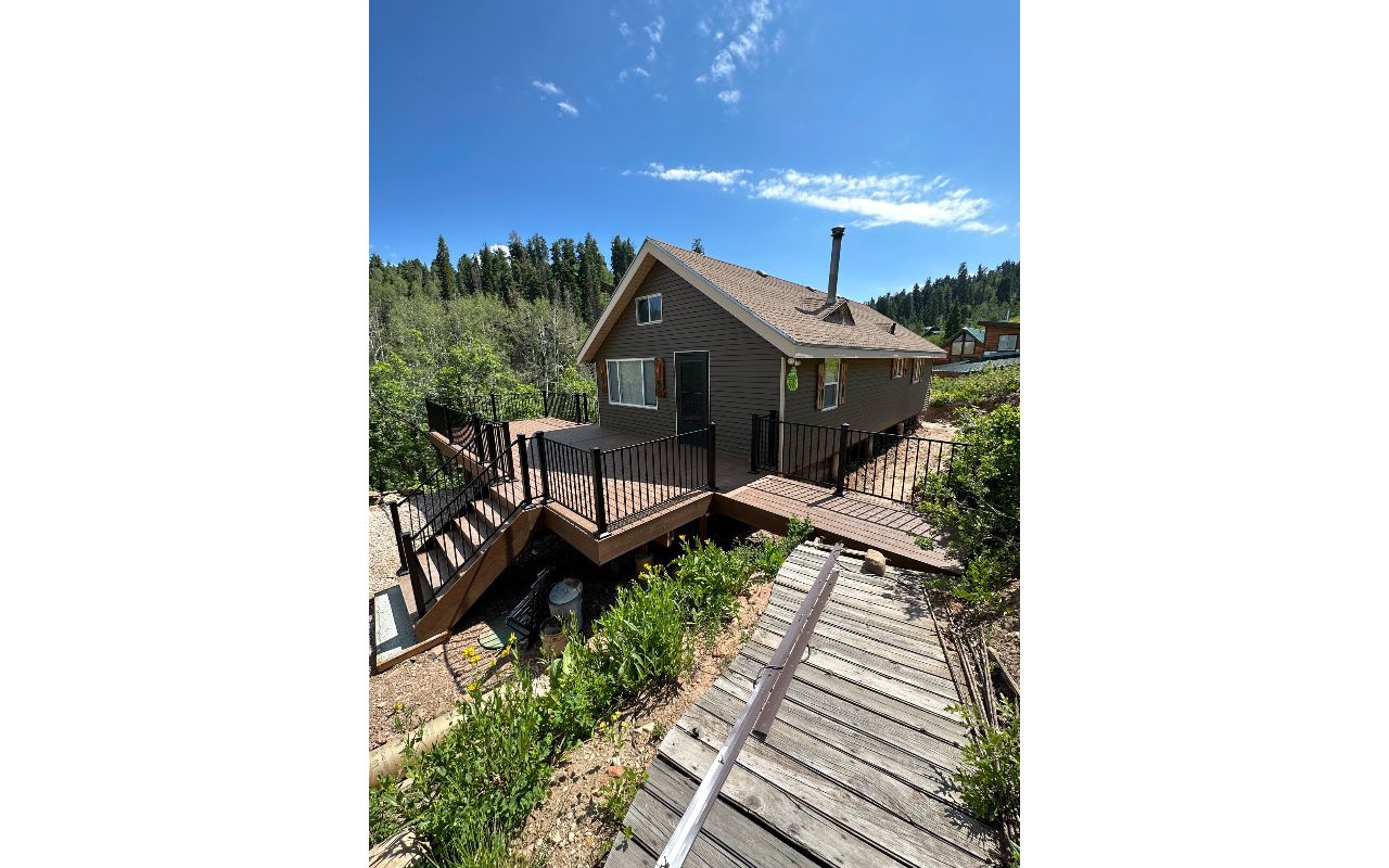 Nestled in the woods, this cabin deck features Trex Select® Saddle decking and sleek Trex® Signature steel railing — blending rustic charm with modern strength.