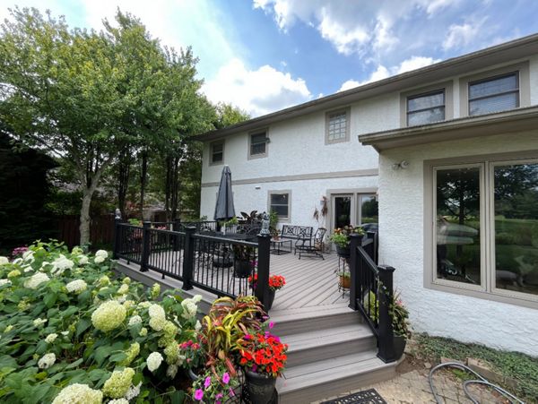 A stunning Rocky Harbor deck with Charcoal Black railing complimented with the customer's green thumb!