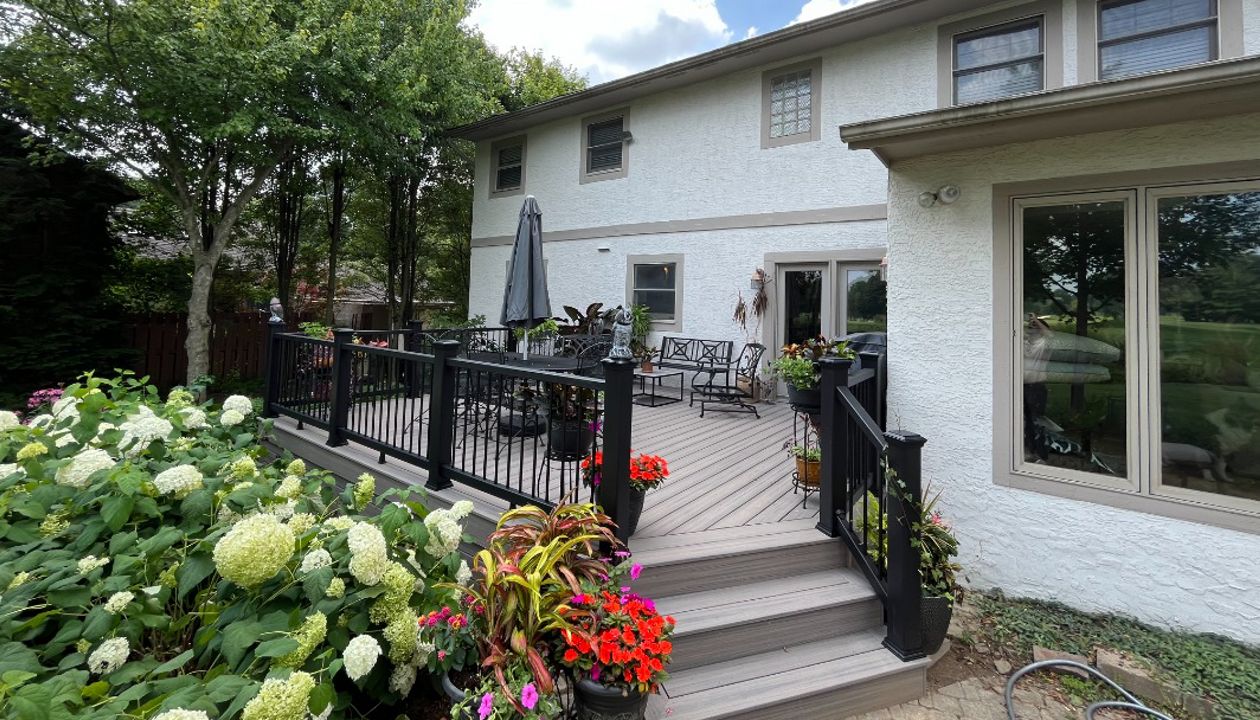 A stunning Rocky Harbor deck with Charcoal Black railing complimented with the customer's green thumb!