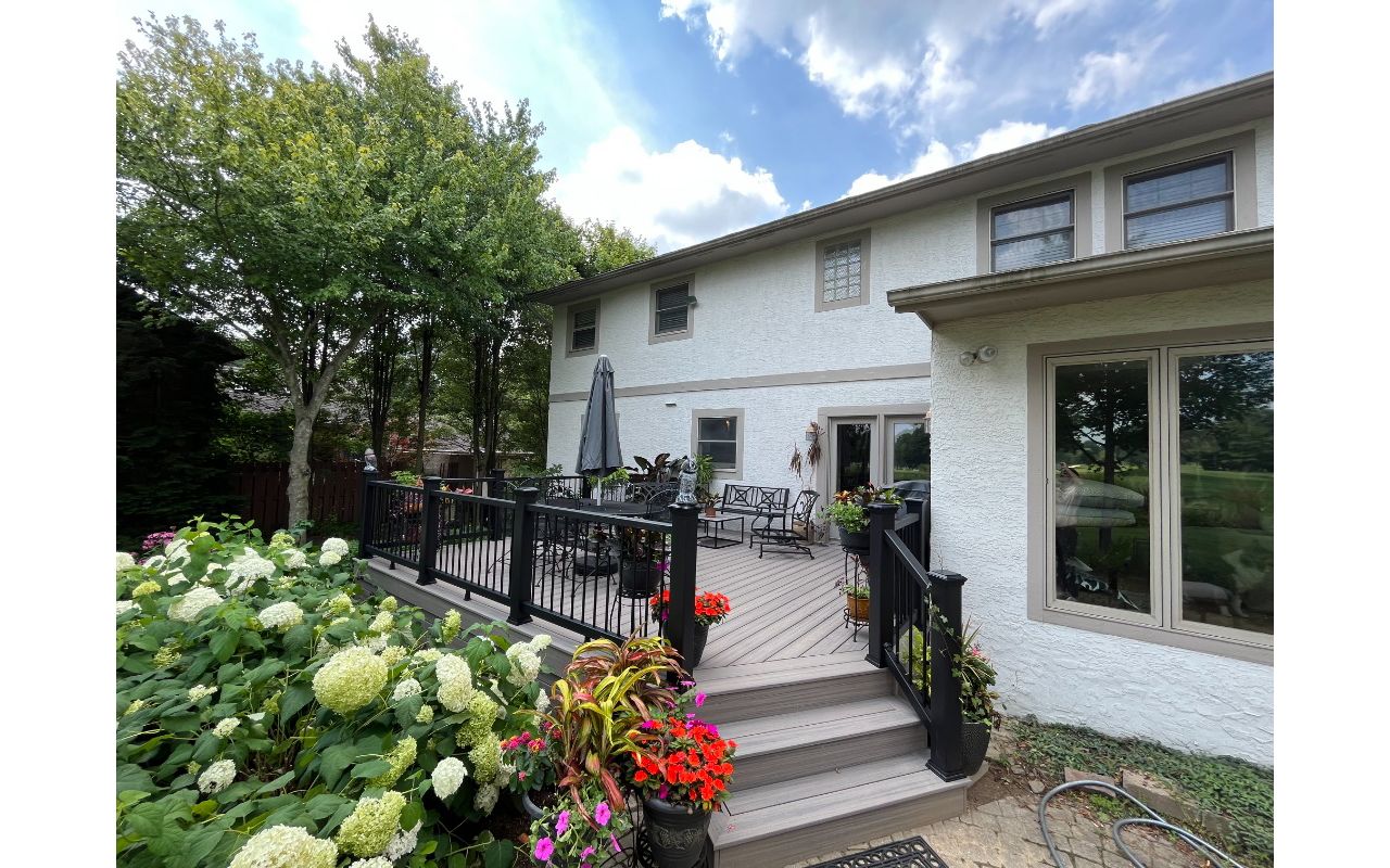 A stunning Rocky Harbor deck with Charcoal Black railing complimented with the customer's green thumb!