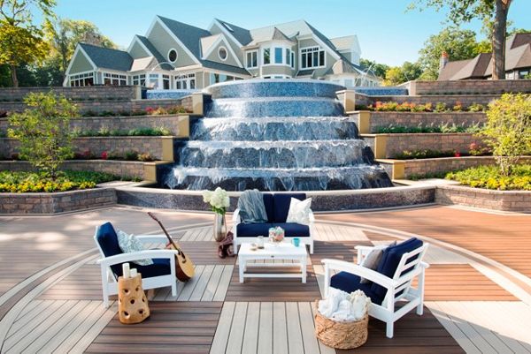 Luxurious multi-level Trex deck with waterfall feature and cozy seating area.