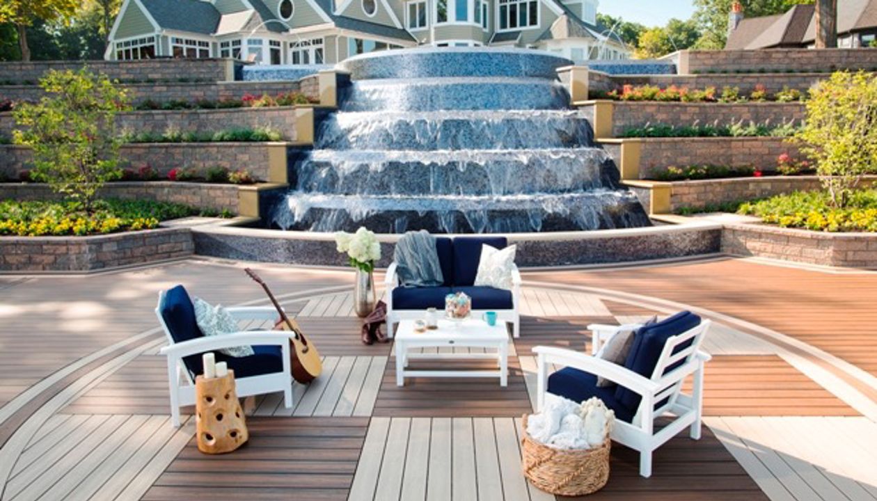 Luxurious multi-level Trex deck with waterfall feature and cozy seating area.