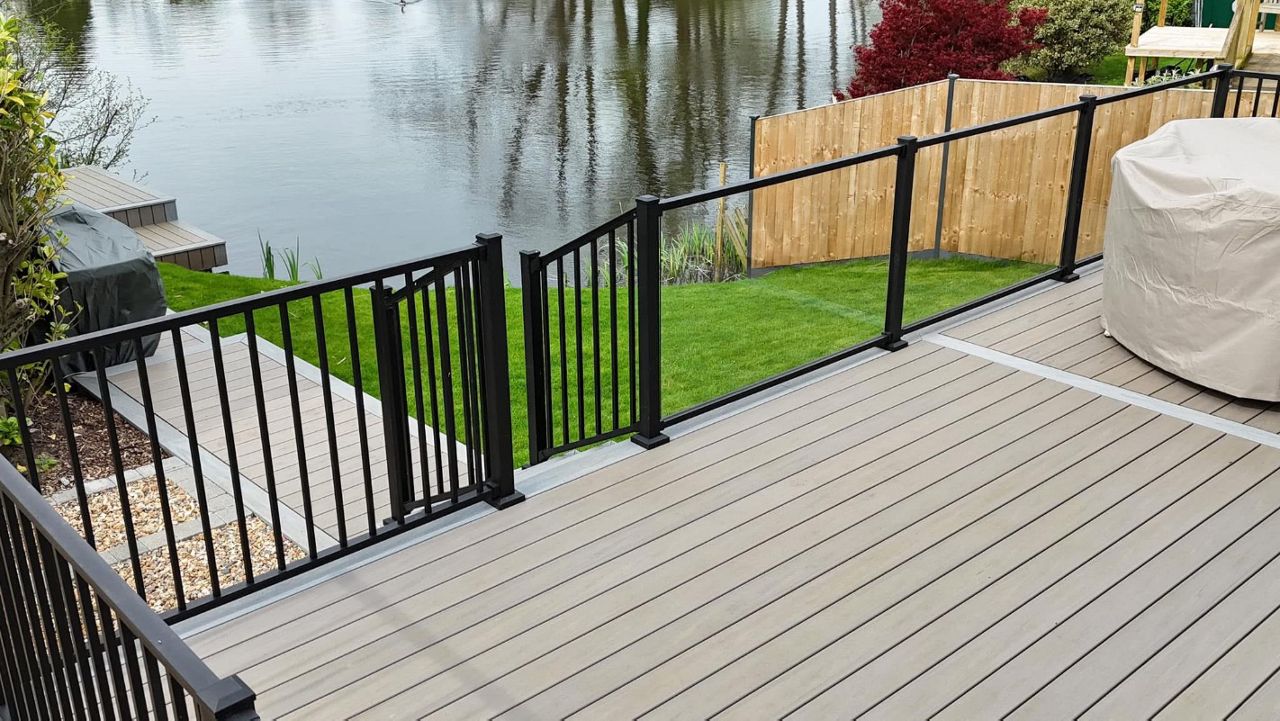 Trex transcend lineage biscayne main field with a picture frame and breaker board in Trex Rainier. Finished with a mix of Trex signature glass and balustrade railing.  Installed @waveney valley lakes.