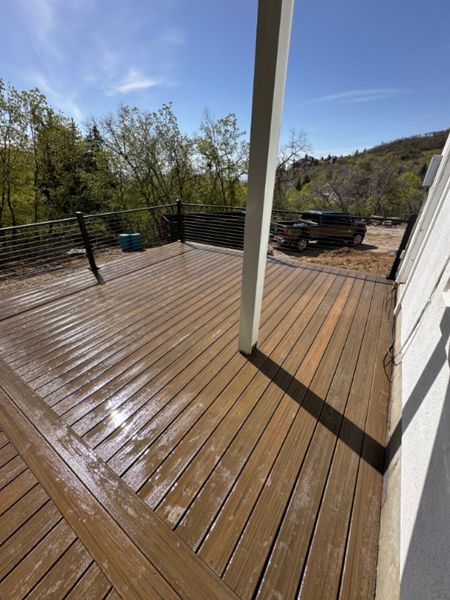 Nestled in a backyard forest, this Cinnamon Cove Trex® deck with cable railing blends natural beauty with modern durability — built to enjoy the outdoors in style.