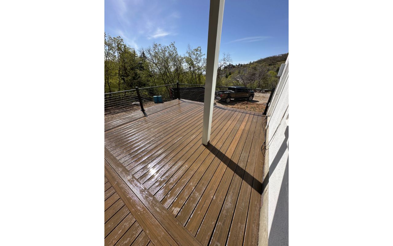 Nestled in a backyard forest, this Cinnamon Cove Trex® deck with cable railing blends natural beauty with modern durability — built to enjoy the outdoors in style.