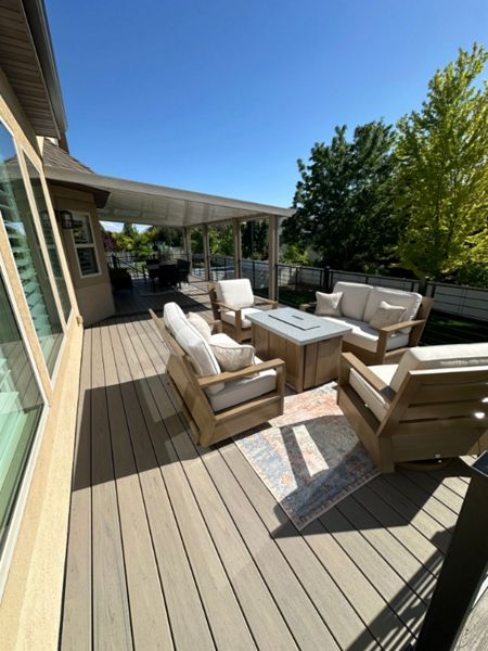 This oversized deck features Trex Biscayne decking with a Spiced Rum double picture frame, Trex Signature® railing, stair lighting, and a full wraparound awning kit. Finished with RainEscape below, it’s built for comfort, function, and serious wow factor.