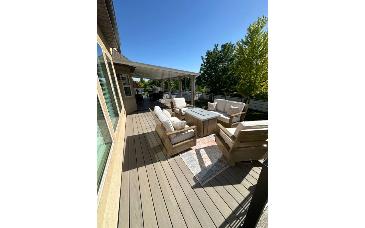 This oversized deck features Trex Biscayne decking with a Spiced Rum double picture frame, Trex Signature® railing, stair lighting, and a full wraparound awning kit. Finished with RainEscape below, it’s built for comfort, function, and serious wow factor.