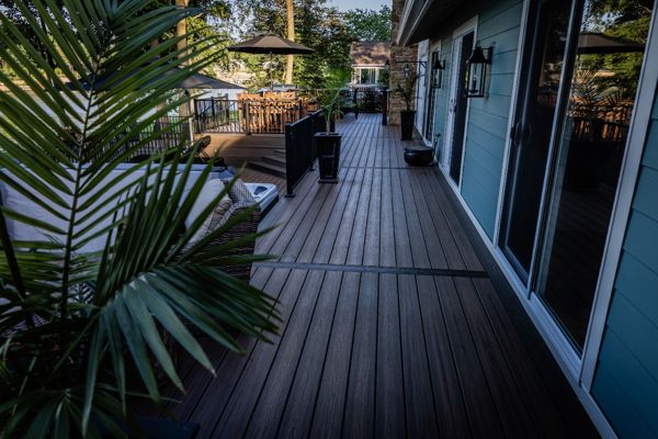 Spacious composite deck walkway with modern railing and integrated gathering spaces connecting multiple outdoor living areas.