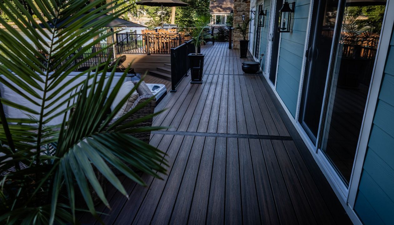 Spacious composite deck walkway with modern railing and integrated gathering spaces connecting multiple outdoor living areas.