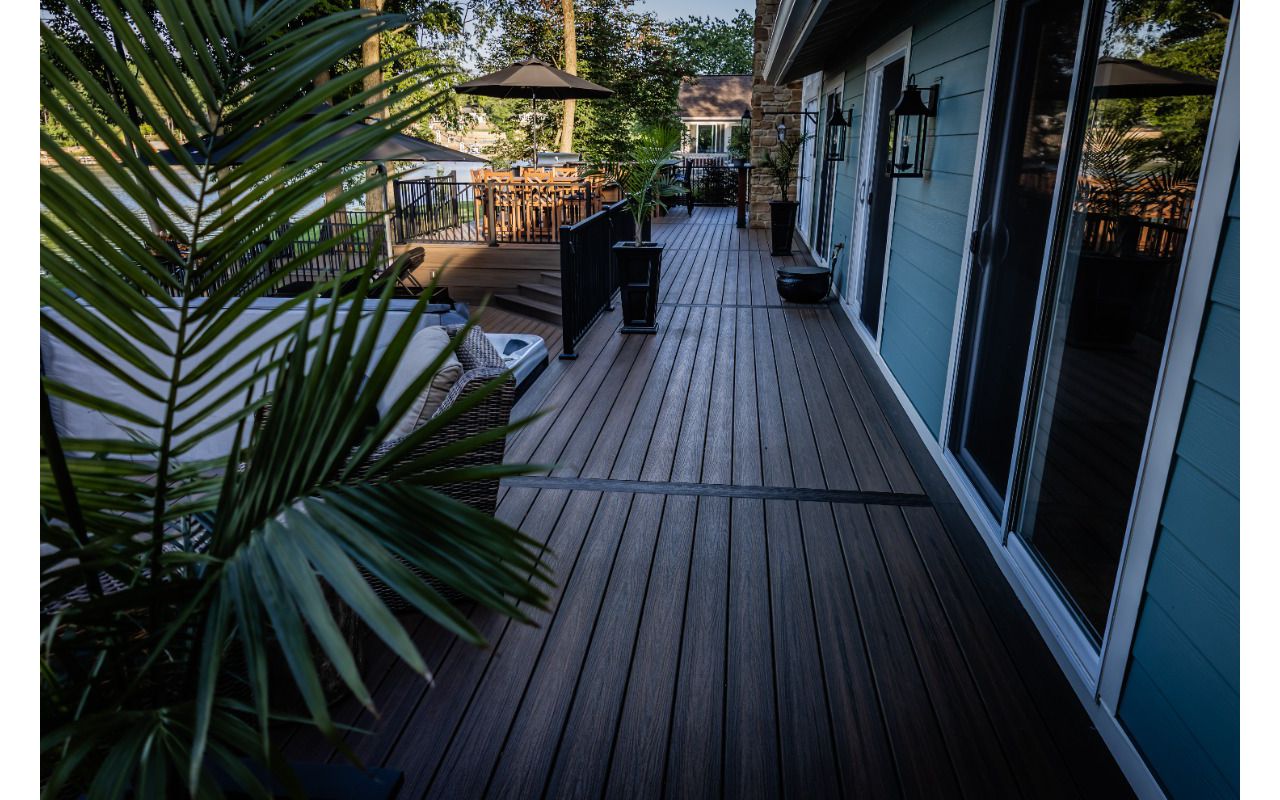 Spacious composite deck walkway with modern railing and integrated gathering spaces connecting multiple outdoor living areas.