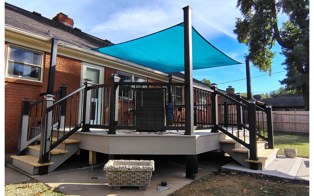 Trex Enhance Basics decking and fascia installation in tide pool color with charcoal black Enhance railing system.