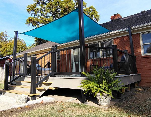 Trex Enhance Basics decking and fascia installation in tide pool color with charcoal black Enhance railing system.