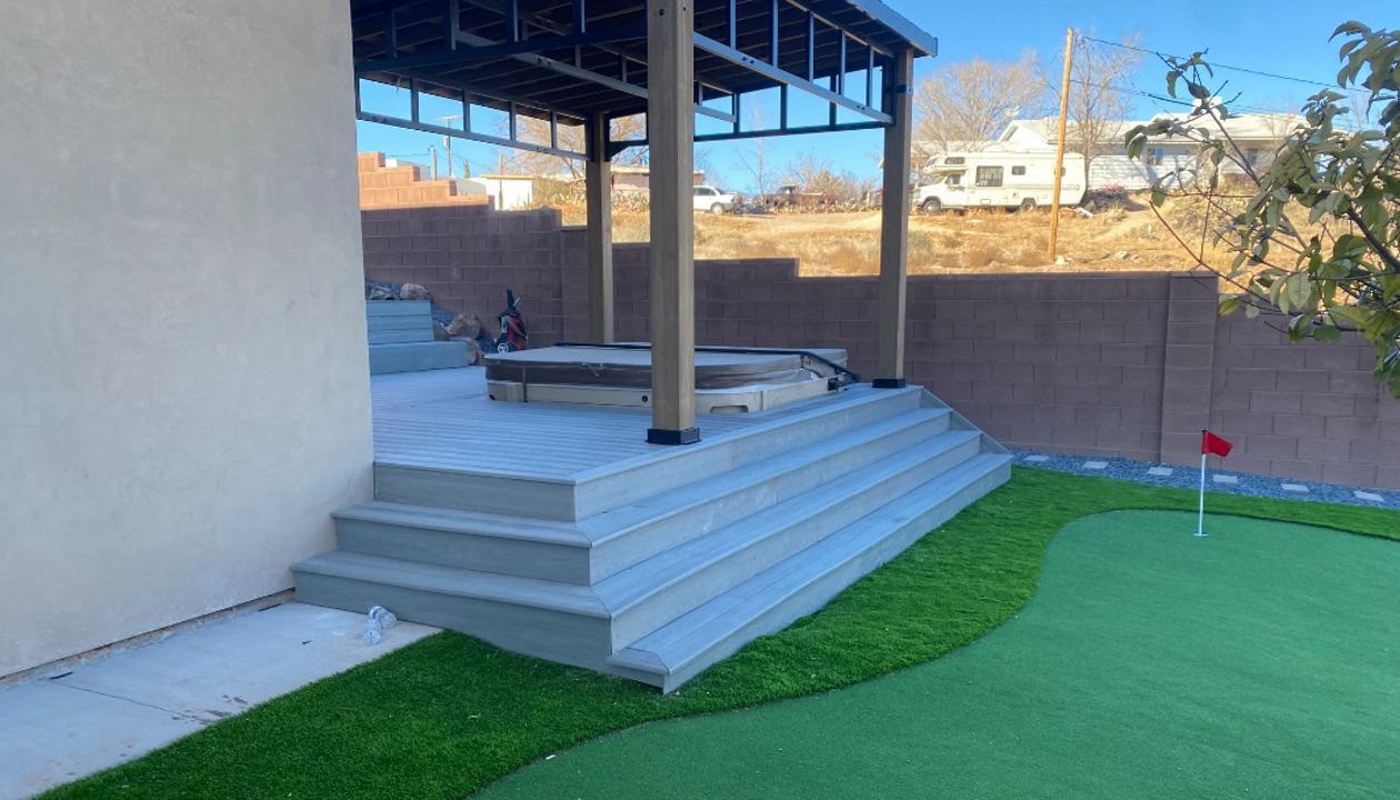 From wraparound stairs to the putting green — this Trex Pebble Grey deck turns your backyard into a private resort. A sunken hot tub, pergola shade, and a view worth the walk make every step a destination.