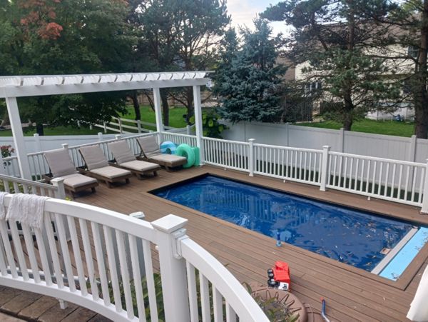 Beautiful, multi-tiered Trex deck with pergola and outdoor dining area.