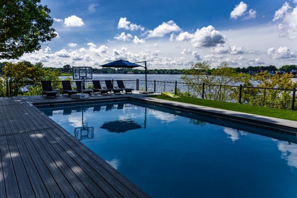 Trex composite pool deck with modern railing and expansive waterfront views.