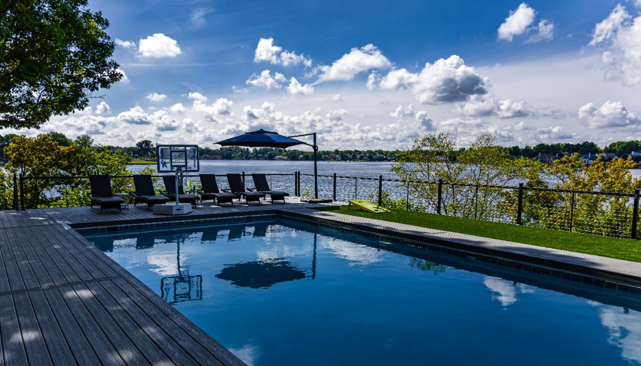 Trex composite pool deck with modern railing and expansive waterfront views.
