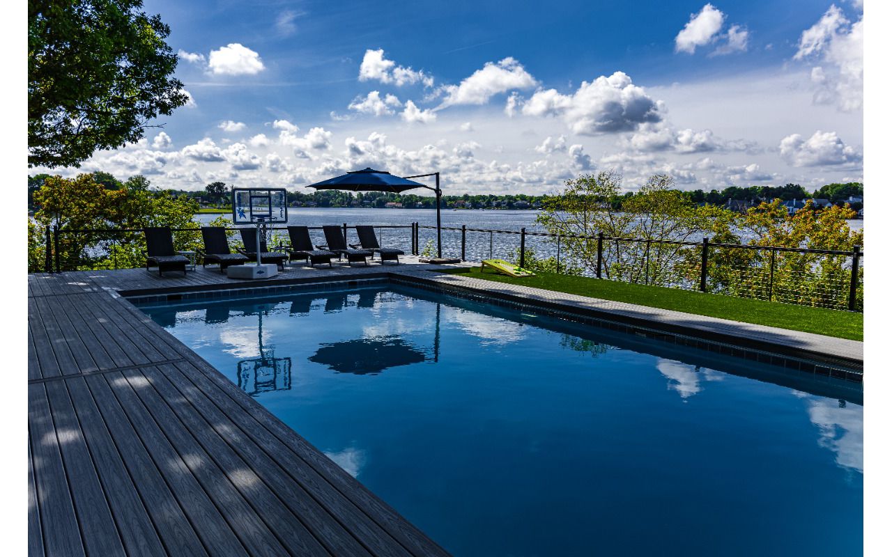 Trex composite pool deck with modern railing and expansive waterfront views.