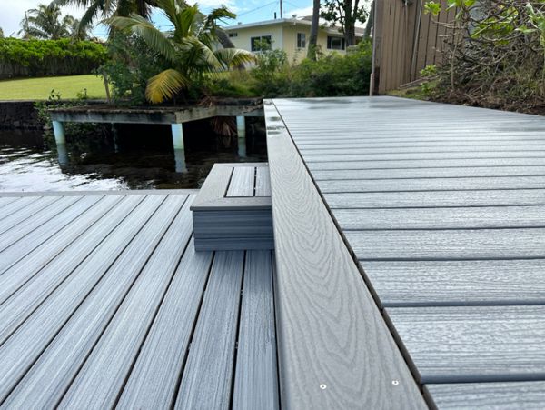 The Kailua deck features Foggy Wharf decking with a Pebble Grey picture frame border and custom steps, designed for a sleek and modern look.