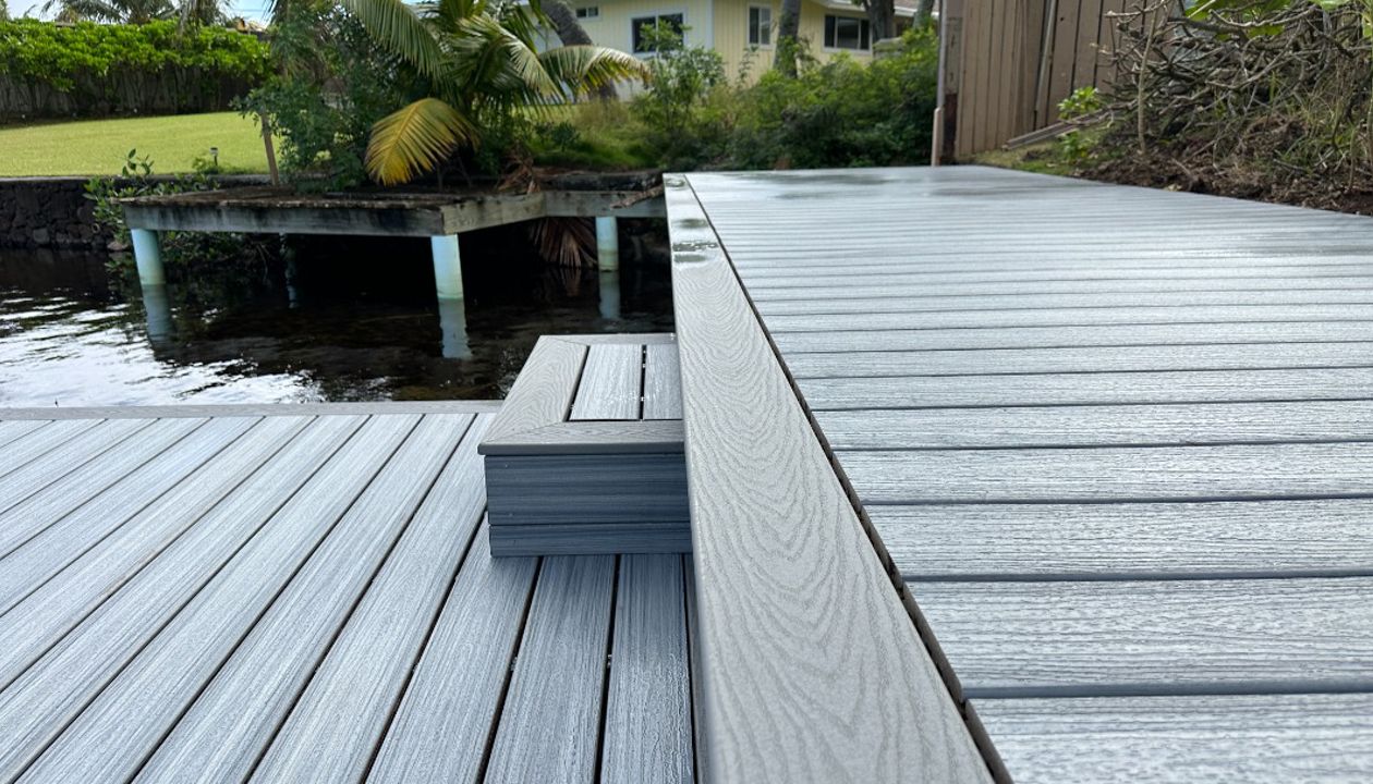 The Kailua deck features Foggy Wharf decking with a Pebble Grey picture frame border and custom steps, designed for a sleek and modern look.