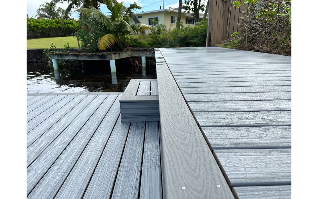 The Kailua deck features Foggy Wharf decking with a Pebble Grey picture frame border and custom steps, designed for a sleek and modern look.