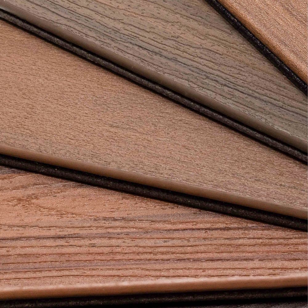 A fan arrangement of laminate flooring samples showcases a variety of wood textures and shades. The image highlights different brown and gray tones, emphasizing the natural grain patterns. The samples are neatly layered on a white background, making the color variations stand out. No visible text, numbers, or identifiable brands are present.