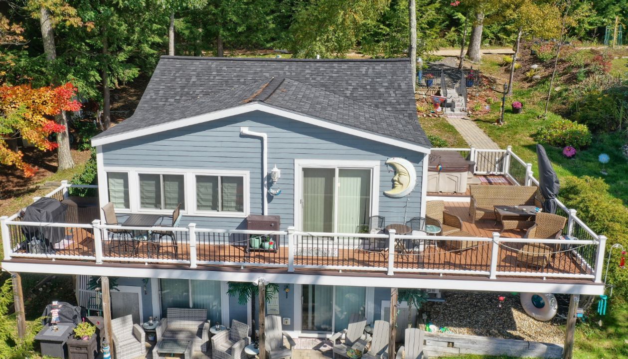 Alton Bay, NH Professional Building Services Wrap Around Deck with Steel Framing and Trex Rain Escapes in Transcend Spiced Rum with Transcend White Railing and Black Metal Balusters