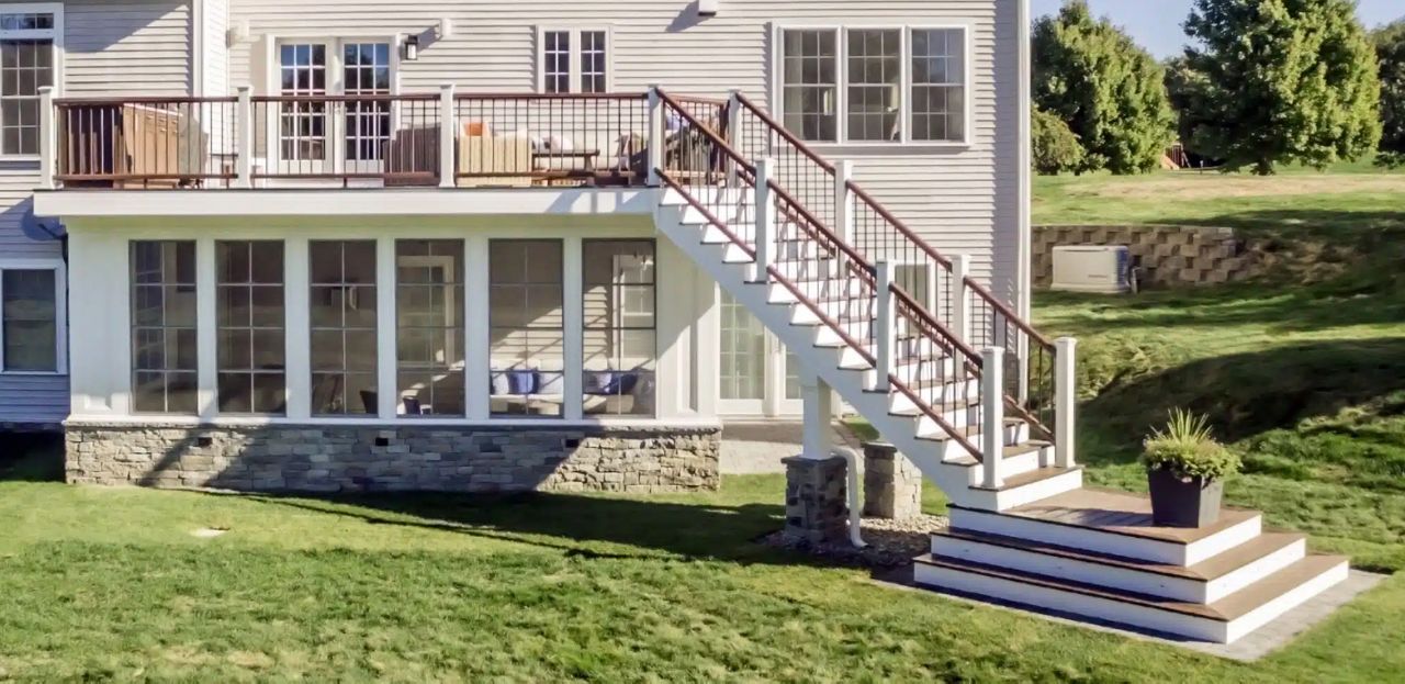 Westford, MA Professional Building Services Design-Build with 4 Season Room, Steel Framing, Cascading Staircase in Transcend Spiced Rum & Vintage Lantern Railing, White Posts, and Black Round Metal Balusters